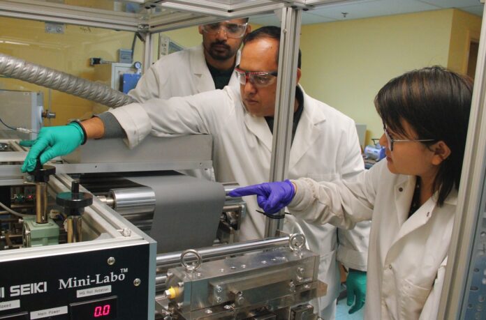 UofL researchers (front to back) Hui Wang, Arjun Thapa and Milinda Bharatha apply a lithium titanate slurry coating to make lithium-ion electrode battery prototypes at UofL’s Conn Center for Renewable Energy Research. The coated anode material is paired with a corresponding cathode sheet to create lithium-ion batteries.